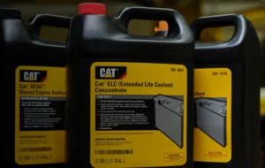 Three black and yellow CAT engine coolant bottles.