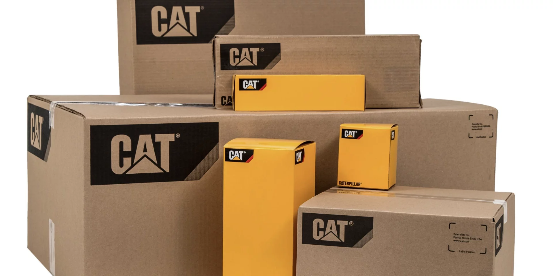 A collection of cardboard boxes filled with genuine Caterpillar yacht engine parts.