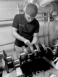 Member of Motortec's dedicated team servicing a CAT engine in black and white