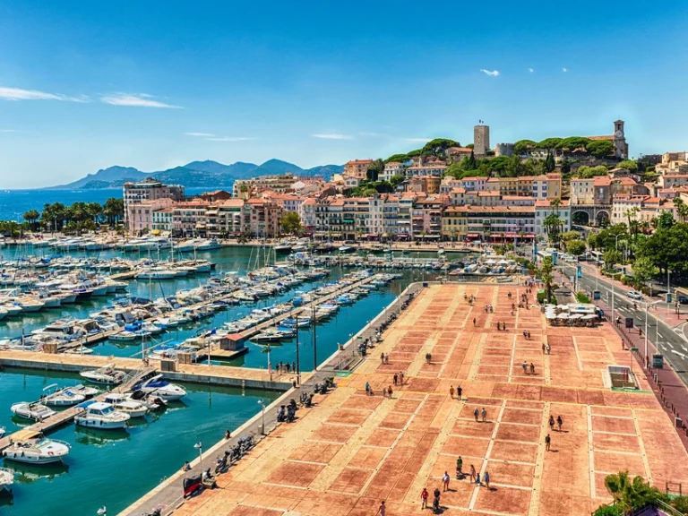Sunny day at Vieux - Port Cannes with yachts berthed on bright blue water